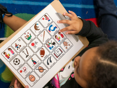 Child looking to a visual support card.