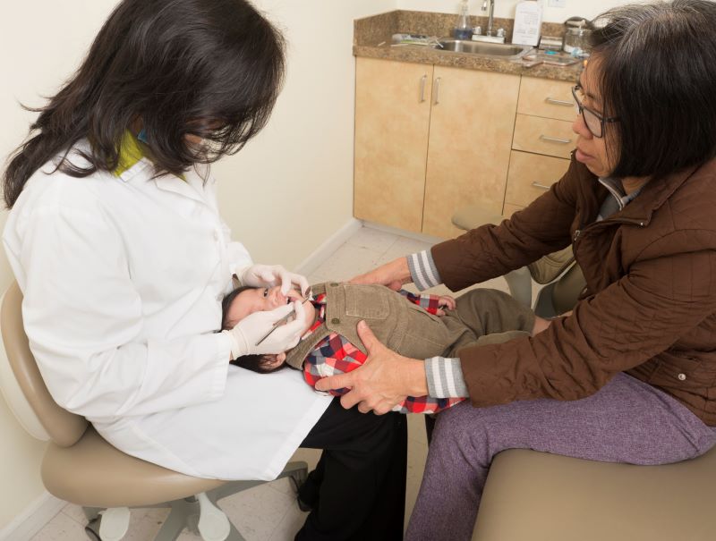 A dentist examining an infant's mouth.