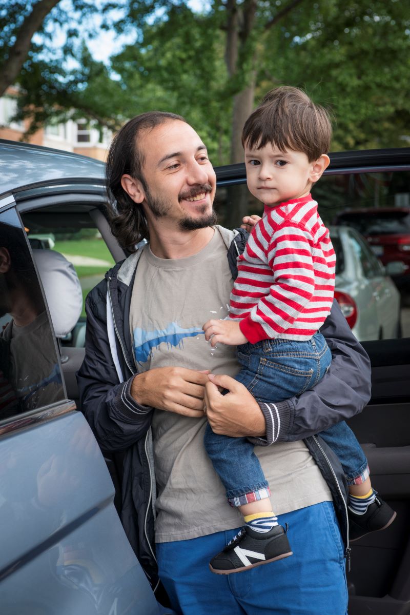 Father holding young son up to his face.