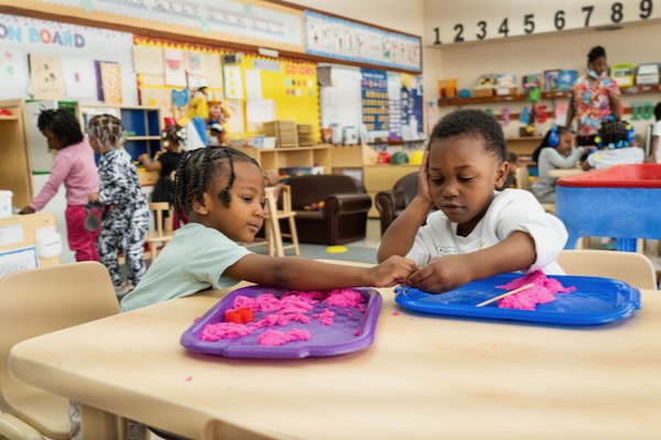 A boy and girl working together on an clay project.
