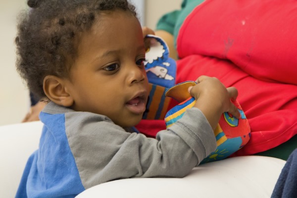 Young child holding on to a toy.