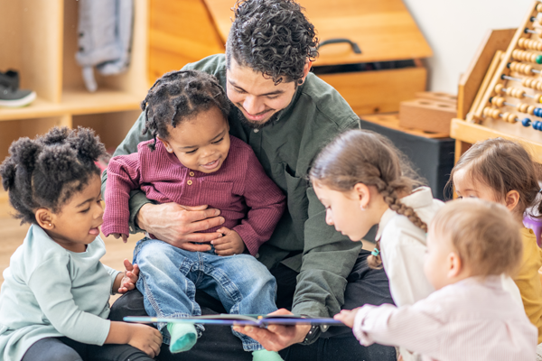 Teacher with children in classroom setting.