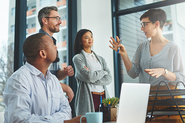 Four people having a discussion in an office setting.
